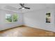 Main bedroom with hardwood floors, tray ceiling, ceiling fan, and large windows at 188 Turnberry Ln, Mooresville, NC 28117