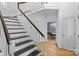 Staircase with hardwood floors and white railings and a view to an open dining area at 188 Turnberry Ln, Mooresville, NC 28117