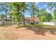Spacious backyard showcasing a well-maintained lawn, patio area, fence, and mature trees at 2020 Olde Towne Dr, Monroe, NC 28110