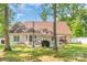Lush backyard featuring a cozy patio area with barbecue, mature trees, and well-manicured lawn at 2020 Olde Towne Dr, Monroe, NC 28110