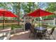 Inviting backyard patio with grill station, dining set, red umbrellas and lush green space at 2020 Olde Towne Dr, Monroe, NC 28110