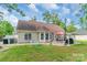 A backyard patio with covered grilling area, seating, and a view of the manicured lawn at 2020 Olde Towne Dr, Monroe, NC 28110