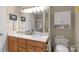 Bright bathroom with double sinks, vanity, and overhead vanity lights and a separate toilet at 2020 Olde Towne Dr, Monroe, NC 28110