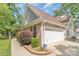 Attached garage with brick and siding exterior, complemented by landscaped flower beds at 2020 Olde Towne Dr, Monroe, NC 28110