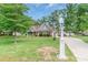 Beautiful home with a well-manicured lawn, mature trees, and a long driveway at 2020 Olde Towne Dr, Monroe, NC 28110