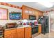 Functional kitchen with wood cabinets and appliances; a television is mounted above the counter at 2020 Olde Towne Dr, Monroe, NC 28110