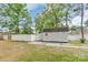 Exterior view of the outdoor storage shed with white fencing and well-maintained green lawn at 2020 Olde Towne Dr, Monroe, NC 28110