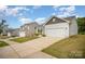 View of home featuring a concrete driveway, neutral siding, white garage door and dark shutters at 2030 Lanza Dr, Charlotte, NC 28215