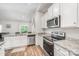 This kitchen features white cabinets, stainless appliances, granite countertops, and hardwood floors at 2030 Lanza Dr, Charlotte, NC 28215
