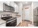 A bright kitchen featuring white cabinets, stainless appliances, and granite countertops at 2030 Lanza Dr, Charlotte, NC 28215