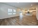 Open concept living area with hardwood floors, bright windows, and a view into the kitchen at 2206 Silverbell Ln, Stanley, NC 28164