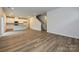 Open-concept living room with stairs and view of kitchen, showcasing hardwood floors at 2206 Silverbell Ln, Stanley, NC 28164