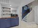 Bright entryway featuring blue cabinetry, wood countertops and a stairway with blue accent wall at 222 Riverview Ter, Clover, SC 29710