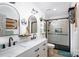 Bright bathroom featuring double sinks, marble countertops, and a modern glass shower with black trim at 27037 Tidal Way, Tega Cay, SC 29708