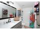Well-lit bathroom with a gray vanity, marble countertops, and a shower-tub combo at 27037 Tidal Way, Tega Cay, SC 29708