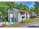 Charming home featuring gray shutters, an American flag, and level yard at 27037 Tidal Way, Tega Cay, SC 29708