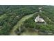 An aerial view of a sprawling golf course surrounded by lush trees, showcasing its beautiful fairways at 27037 Tidal Way, Tega Cay, SC 29708