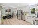 Open kitchen featuring stainless steel appliances, white cabinets, a dining area, and lots of natural light from the window at 27037 Tidal Way, Tega Cay, SC 29708