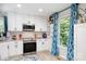 Modern white kitchen with stainless steel appliances, white cabinets, and a window view at 27037 Tidal Way, Tega Cay, SC 29708