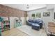 Cozy living room with brick accent wall, comfortable blue sofa, and natural light at 27037 Tidal Way, Tega Cay, SC 29708