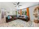 Bright living room featuring a ceiling fan, a large sectional sofa, and decorative throw pillows at 27037 Tidal Way, Tega Cay, SC 29708