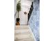 A staircase features a white door, light wood steps and a blue/white flower wallpaper at 27037 Tidal Way, Tega Cay, SC 29708