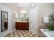 Bathroom featuring checkered flooring, vanity with mirror, soaking tub and white door at 2804 Pulaski Dr, Monroe, NC 28110