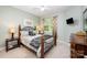 Bedroom with a metal bedframe, side tables, lamps, large window, and light-green colored walls at 2804 Pulaski Dr, Monroe, NC 28110