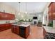 Open concept kitchen with tile floors, cherry cabinets, granite counters, and views into the living room at 2804 Pulaski Dr, Monroe, NC 28110