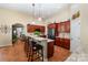 Spacious kitchen with cherry cabinets, a center island with seating, and open access to the living area at 2804 Pulaski Dr, Monroe, NC 28110