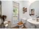 Charming powder room featuring pedestal sink, window and tiled floors at 2804 Pulaski Dr, Monroe, NC 28110