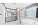 Well-lit bathroom with dual sink vanity, glass shower, and soaking tub under a bright window at 3615 Alamito Ln, Charlotte, NC 28214