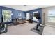 Bonus room featuring blue accent wall, carpet, a comfy couch and an exercise bike at 3615 Alamito Ln, Charlotte, NC 28214