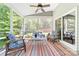 Inviting screened porch with ceiling fan, comfortable seating, and colorful striped rug at 3615 Alamito Ln, Charlotte, NC 28214