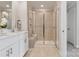 Elegant bathroom featuring double sinks, a glass-enclosed shower and neutral tile at 4209 Summit Woods Dr, Charlotte, NC 28216