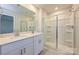 Modern bathroom featuring double sinks, a large mirror and a glass-enclosed shower at 4209 Summit Woods Dr, Charlotte, NC 28216