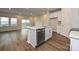Bright kitchen featuring an island, stainless steel dishwasher, and wood-look floors at 4209 Summit Woods Dr, Charlotte, NC 28216