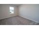This bedroom features neutral walls, plush carpet, and a window providing natural light at 4213 Summit Woods Dr, Charlotte, NC 28216
