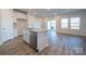 Bright kitchen featuring a granite island, stainless steel appliances, white cabinets, and wood-look flooring, perfect for entertaining at 4213 Summit Woods Dr, Charlotte, NC 28216