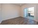 Bright living room showcasing wood-look flooring, large windows, and sliding glass doors for access to the outdoors at 4213 Summit Woods Dr, Charlotte, NC 28216