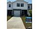 Charming townhome with a one-car garage, a well-manicured lawn, and a sidewalk leading to the front door at 4217 Summit Woods Dr, Charlotte, NC 28216