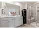 Modern bathroom featuring a double sink vanity, large mirror, black cabinet, and tiled glass door shower at 4229 Summit Woods Dr, Charlotte, NC 28216