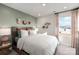 Bedroom with a light green accent wall, unique animal decor, and a window with light filtering curtains at 4229 Summit Woods Dr, Charlotte, NC 28216