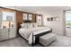 Bedroom featuring large windows, patterned accent wall, and a cushioned bench at the foot of the bed at 4229 Summit Woods Dr, Charlotte, NC 28216