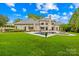 Large home featuring a spacious backyard with a pool, lush lawn and green landscaping at 4523 Fox Brook Ln, Charlotte, NC 28211