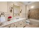 Well-lit bathroom with tiled walls and floors, custom vanity, and a shower-tub combination at 4523 Fox Brook Ln, Charlotte, NC 28211