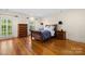 Inviting bedroom featuring hardwood floors, neutral walls, and ample natural light from large windows at 4523 Fox Brook Ln, Charlotte, NC 28211