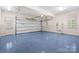 Spacious garage with epoxy flooring, ample lighting, and large garage door to easily park vehicles at 4523 Fox Brook Ln, Charlotte, NC 28211