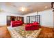 Spacious living room featuring hardwood floors, decorative ceiling, and comfortable red seating at 4523 Fox Brook Ln, Charlotte, NC 28211