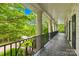 Covered porch featuring stone columns and wrought iron railings, offering serene outdoor living at 4523 Fox Brook Ln, Charlotte, NC 28211